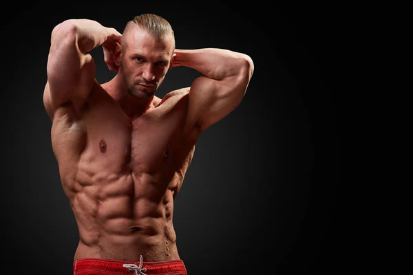 Hombre atlético posando. Foto de hombre con físico perfecto sobre fondo negro. Fuerza y motivación —  Fotos de Stock