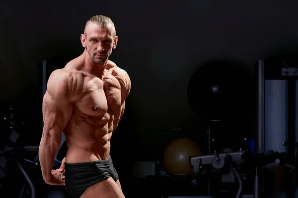 Athletic man posing. Photo of man with perfect physique on black background. Strength and motivation — Stock Photo, Image