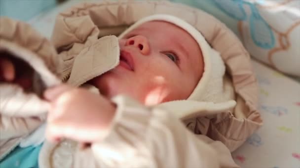 Lieve kleine baby gekleed in knittede thuis in zonnige slaapkamer — Stockvideo