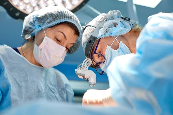 El equipo de cirujanos hace una operación invasiva. Retrato de cirujanos de cerca. Trabajar con un instrumento coagulante, coagulación vascular — Foto de Stock