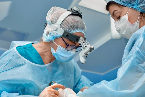 Team av kirurger gör en invasiv åtgärd. Porträtt av kirurger närbild. Arbeta med ett koagulera instrument, vaskulär koagulation — Stockfoto