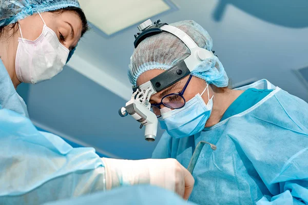 Team of surgeons makes an invasive operation. Portrait of surgeons close-up. Work with a coagulating instrument, vascular coagulation — Stock Photo, Image