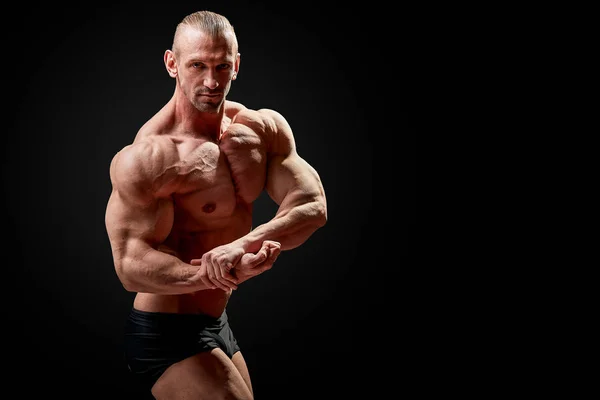 Hombre atlético posando. Foto de hombre con físico perfecto sobre fondo negro. Fuerza y motivación —  Fotos de Stock