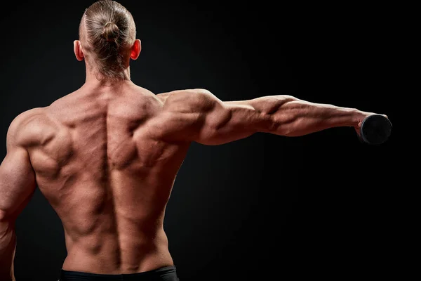 Hombre atlético posando. Foto de hombre con físico perfecto sobre fondo negro. Vista trasera. Fuerza y motivación —  Fotos de Stock