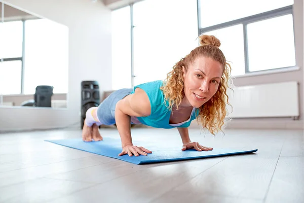 Spor salonunda sıkılmış atletik çekici kadın. Eğitim kavramı, spor, egzersiz işlemi — Stok fotoğraf