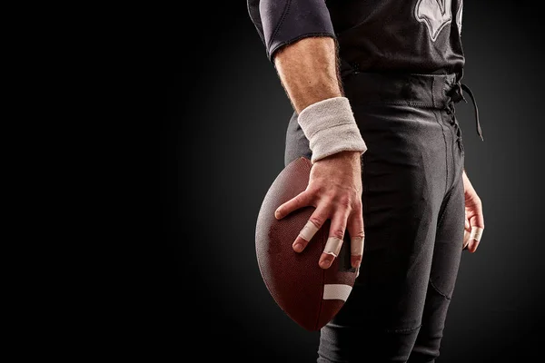 Mitten av avsnittet i amerikansk fotbollsspelare med bollen mot svart, kopia utrymme, side view — Stockfoto