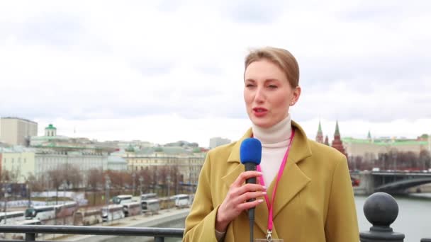 Mladá dívka televizní reportér vysílá na pozadí moderní město — Stock video
