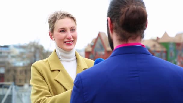 Ung attraktiv kvinnlig journalist intervjuar en ung affärsman i staden. Ung kvinna som arbetar som media Tv-reporter med affärsman. — Stockvideo