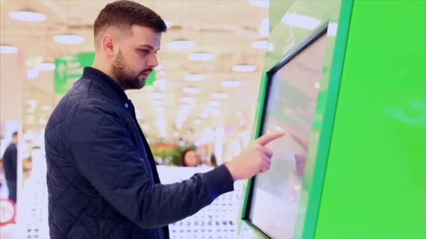 2019年4月12日，俄罗斯莫斯科：互动购物中心地图标志，供游客使用。特大城市购物中心，莫斯科。一名男子在购物中心的互动地图上搜索. — 图库视频影像
