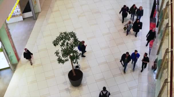 Vue de dessus des personnes marchant dans le grand hall de l'intérieur du bâtiment moderne dans le centre commercial . — Video