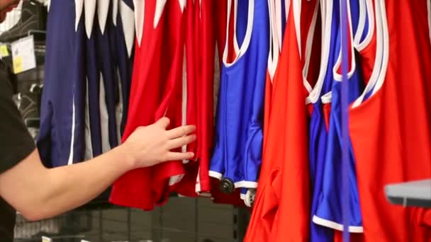 De man in de winkel kiest sportkleding. Concept van aankoop. — Stockvideo