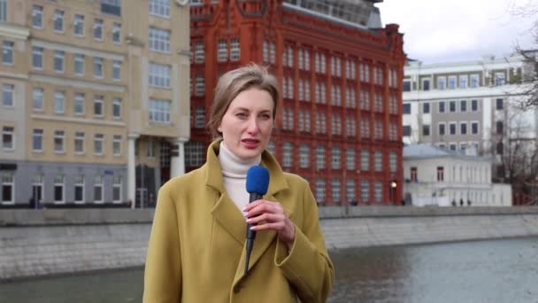 Giornalista caucasica femminile con microfono che riporta notizie su strada — Video Stock