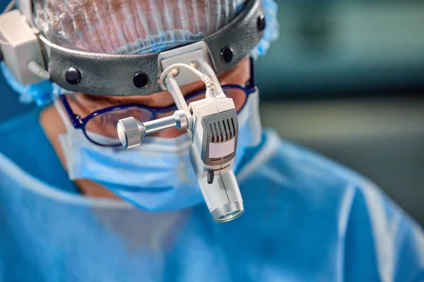 Retrato de cerca de la doctora cirujana usando máscara protectora y sombrero durante la operación. Salud, educación médica, concepto de cirugía . — Foto de Stock