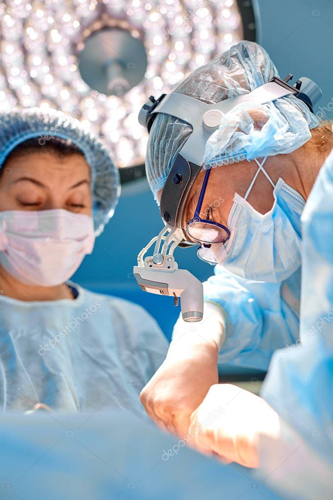 Shot in Operating Room, Assistant Hands out Instruments to Surgeons During Operation. Surgeons Perform Operation. Medical Doctors Performing Surgery.