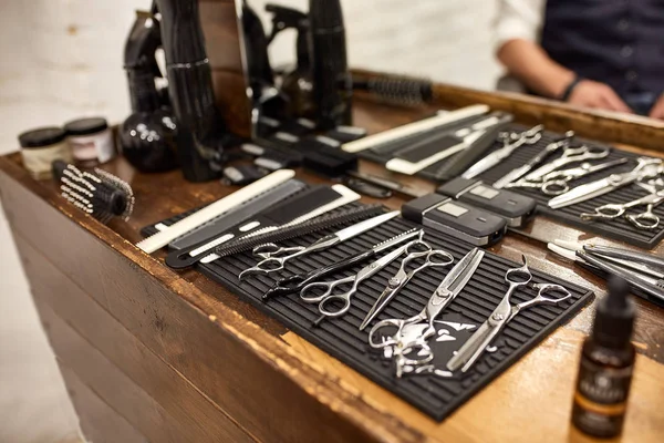 Barber tools on wooden shelf and mirror in barbershop — Stock Photo, Image
