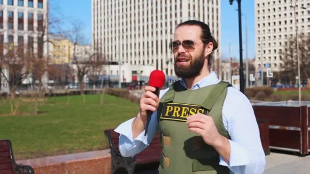 Επιτυχημένος δημοσιογράφος με μικρόφωνο στο χέρι μιλάει ζωντανά στο δρόμο — Αρχείο Βίντεο