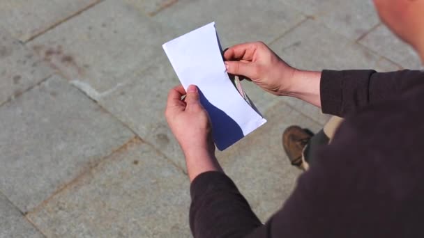 Молодой человек проверяет деньги, которые в конверте. Он считает. . — стоковое видео