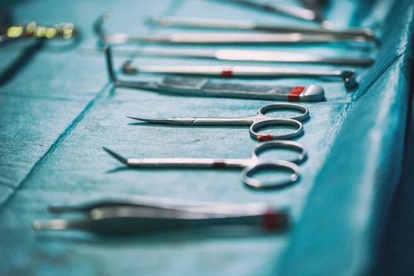 Conjunto de instrumentos estériles dispuestos sobre la mesa para una operación sobre un paño azul — Foto de Stock