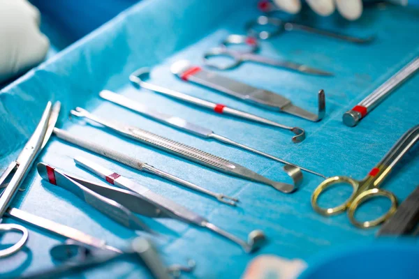 Conjunto de instrumentos estériles dispuestos sobre la mesa para una operación sobre un paño azul — Foto de Stock