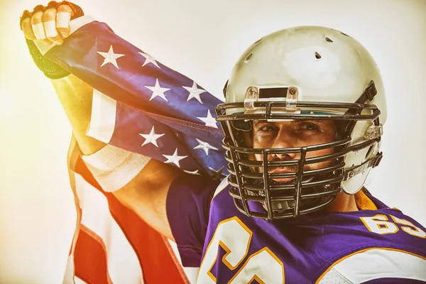 Football Player with uniform and a american flag celebrates victory, on a white background.