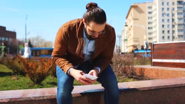 Передача хабарів на вулиці. Чоловік дає гроші в конверті іншому чоловікові, сидячи на лавці в парку — стокове відео
