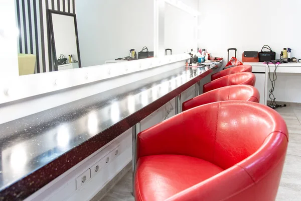 Camarim brilhante com cadeiras vermelhas. um quarto simples para maquiagem várias cadeiras confortáveis estão em uma fileira . — Fotografia de Stock