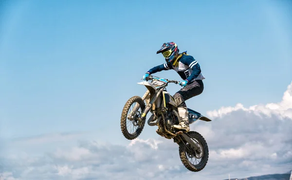 Uma foto de um motociclista fazendo uma acrobacia e salta no ar — Fotografia de Stock