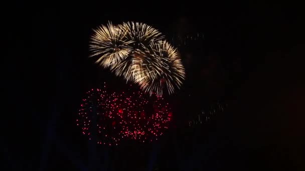 Exhibición de fuegos artificiales en la noche sobre fondo negro. Brillantes explosiones rojas verdes amarillas. Increíblemente hermosa — Vídeos de Stock