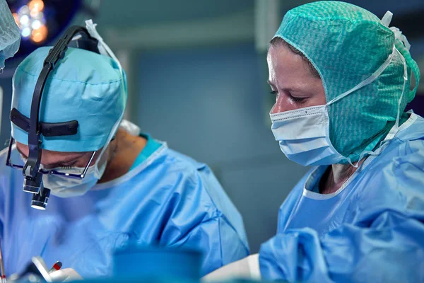 Team of surgeons makes an invasive operation. Portrait of surgeons close-up. Work with a coagulating instrument, vascular coagulation — Stock Photo, Image