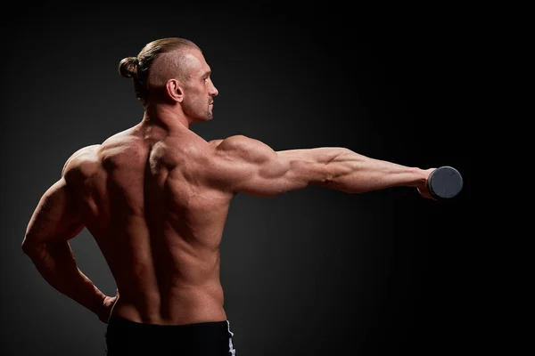 Sportovní koncept. Fitness sportovec s dokonalým svaly na kameře na černém pozadí. — Stock fotografie