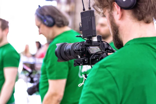 Videógrafo filmando um filme ou um programa de televisão em um estúdio com uma câmera profissional, nos bastidores — Fotografia de Stock