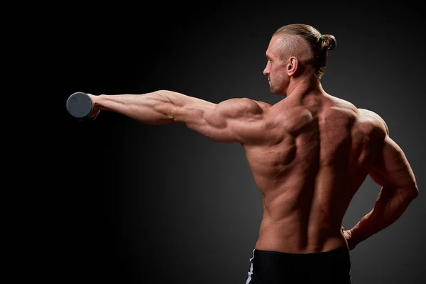 Conceito desportivo. Atleta de fitness com músculos perfeitos posa na câmera sobre fundo preto . — Fotografia de Stock