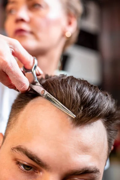 Der Meister schneidet sich im Salon die Haare. Schere, Roschetsk aus nächster Nähe. Konzept Friseur, Haarschnitt, Schönheit. — Stockfoto