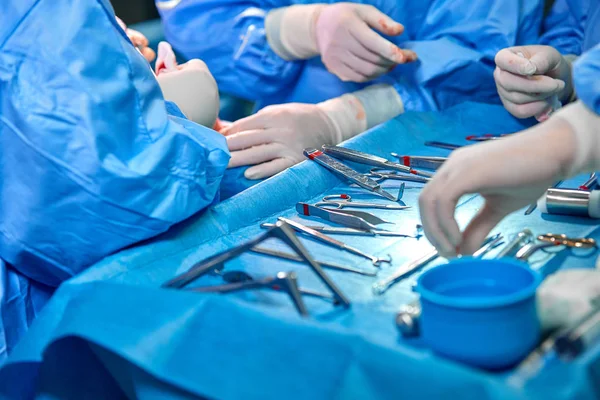 Instrumentos e instrumentos quirúrgicos, incluyendo bisturíes, fórceps y fórceps, ubicados sobre la mesa para cirugía. Medicina, cirugía, salvar vidas . — Foto de Stock
