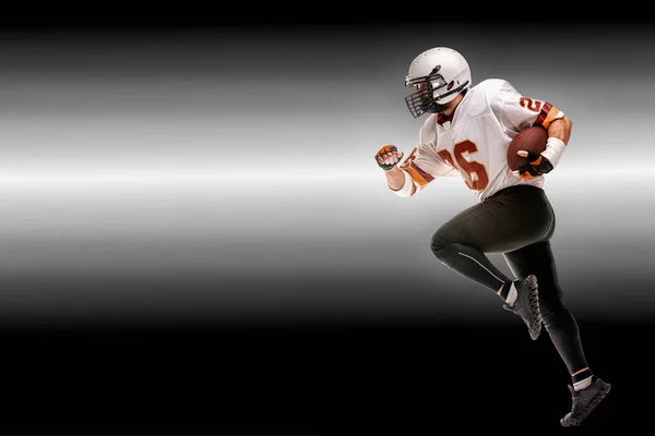 Concept american football, american football player with ball in hand. Black white background, copy space. American football sportsman player in action — Stock Photo, Image