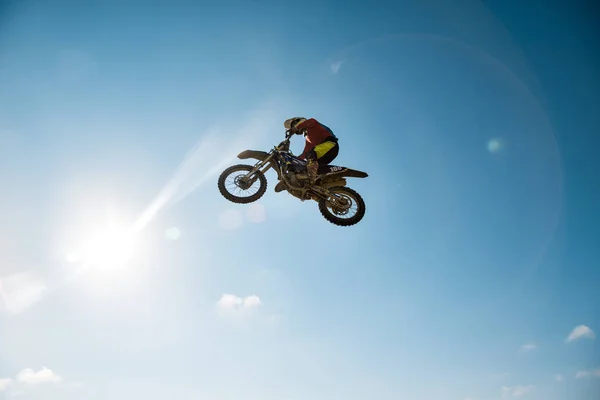 Uma foto de um motociclista fazendo uma acrobacia e salta no ar — Fotografia de Stock