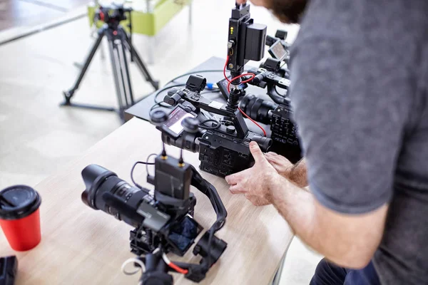Videografo che gira un film o un programma televisivo in uno studio con una macchina fotografica professionale, dietro le quinte — Foto Stock