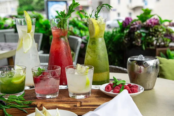 Refrescos de verano, un juego de limonadas. Limonadas en jarras sobre la mesa, cuyos ingredientes se preparan se disponen alrededor . — Foto de Stock