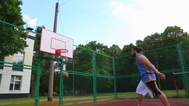 Jugador de baloncesto entrena en la calle para anotar la pelota en la canasta. Juego de entrenamiento de baloncesto. Concepto deporte, motivación, logro de metas, estilo de vida saludable . — Vídeos de Stock