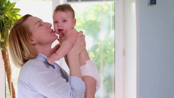 A loving happy young mother hugs a nursing son in the nursery. Beautiful light. The concept of love, family and happiness, children, baby, newborns. — Stock Video