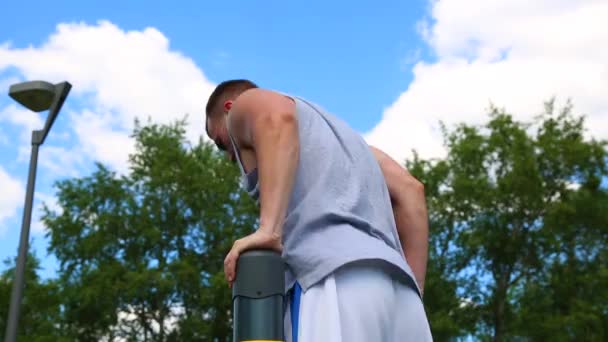 Sport motivations. Muscular athlete wrung out on uneven bars outdoors on a sunny day. Healthy lifestyle, body development, beauty, crossfit. — Stock Video