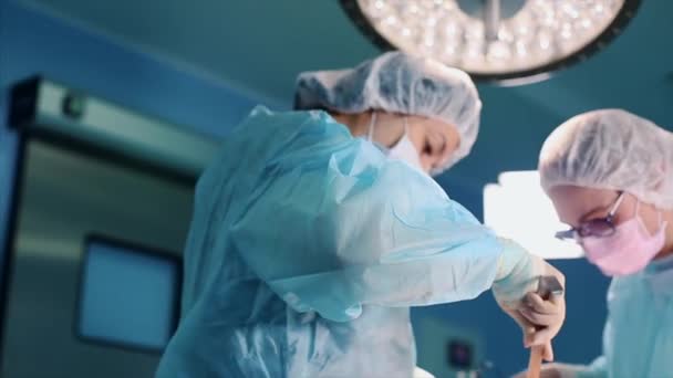 En el quirófano, dos cirujanos durante una operación. Médicos profesionales en un hospital moderno. Cirugía plástica, medicina moderna,. equipo profesional de médicos. Concepto belleza, salud . — Vídeos de Stock