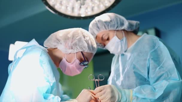 Dans la salle d'opération, deux chirurgiens pendant une opération. Médecins professionnels dans un hôpital moderne. Chirurgie plastique, medetsin moderne,. équipe professionnelle de médecins. Concept beauté, santé . — Video