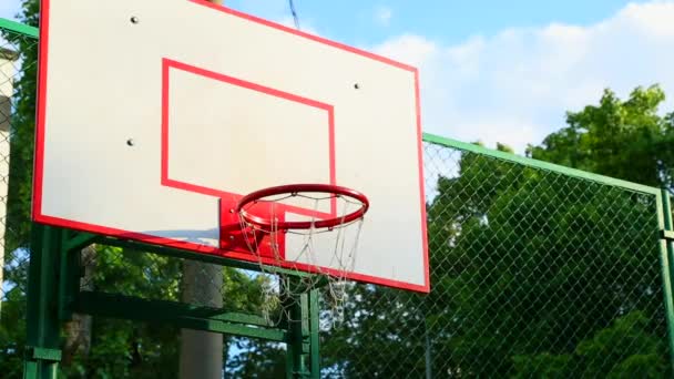 バスケットボールの指輪通りのクローズアップでバスケットボールのリングのシーンは、ネットが風に揺れる。スポーツ、バスケットボール. — ストック動画