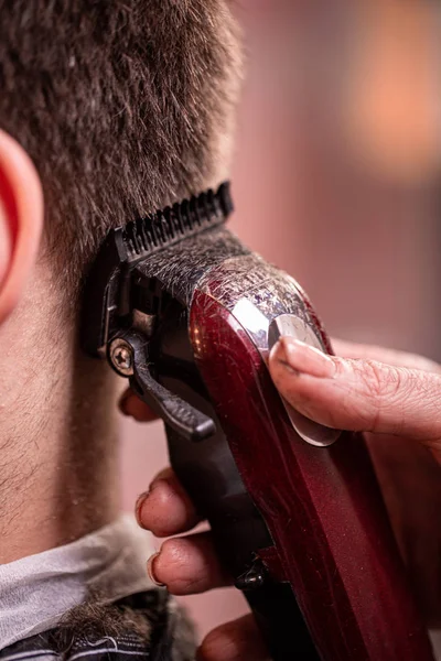 Nahaufnahme mit Haarschnitt. Hände, die einen Haarschneider halten. Friseur, Stilgestaltung, Schönheit. Schönheitssalon. — Stockfoto