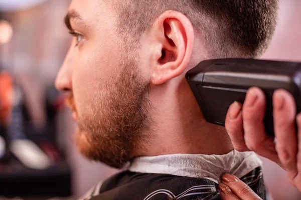 Nahaufnahme mit Haarschnitt. Hände, die einen Haarschneider halten. Friseur, Stilgestaltung, Schönheit. Schönheitssalon. — Stockfoto