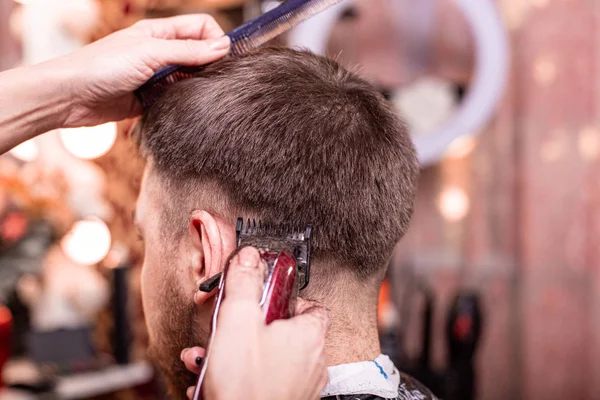 Nahaufnahme mit Haarschnitt. Hände, die einen Haarschneider halten. Friseur, Stilgestaltung, Schönheit. Schönheitssalon. — Stockfoto