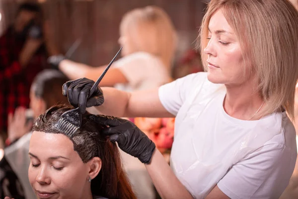 サロンでのヘアカラーリング、ヘアスタイリング。プロのウィザードは、サロンで髪を描きます。美容コンセプト、ヘアケア. — ストック写真