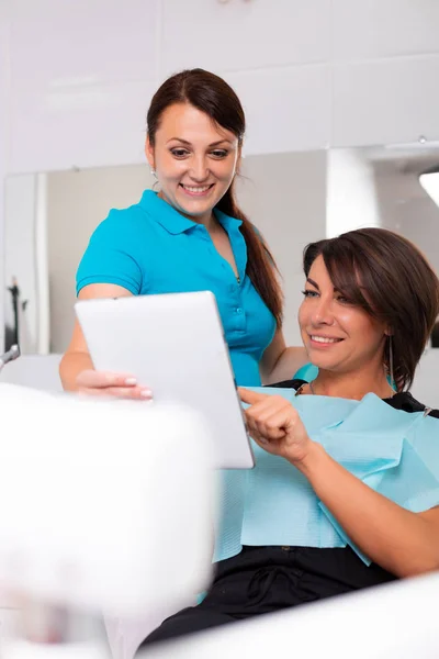 Zubař na digitální obrazovce ukazuje zuby rentgenové. Pacient sedící na židli na profesionální zubní klinice — Stock fotografie