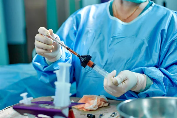 Hands hold syringes to carry fat during work. The operation to transfer fat from one part of the body to another. Platsichiskaya surgery, beauty, change of appearance.